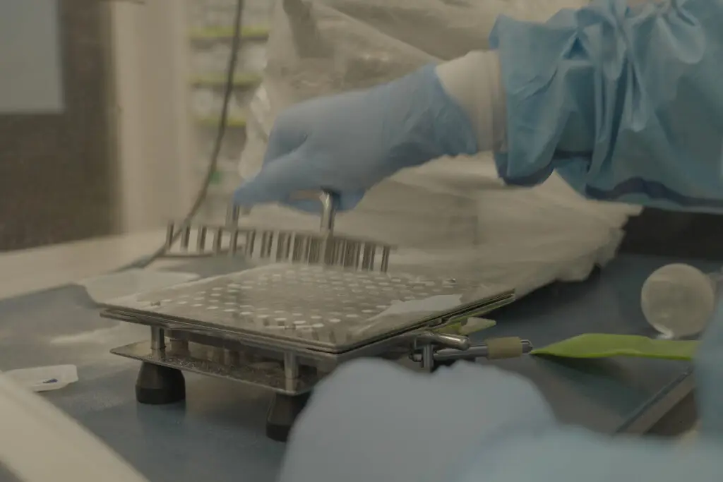 Compounding Pharmacist in lab using a capsule machine.